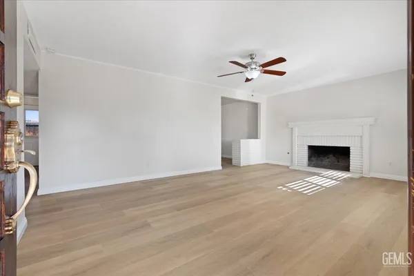 a view of empty room with a fireplace and fan