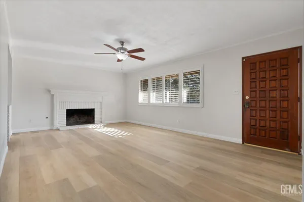a view of an empty room with a fireplace and a window