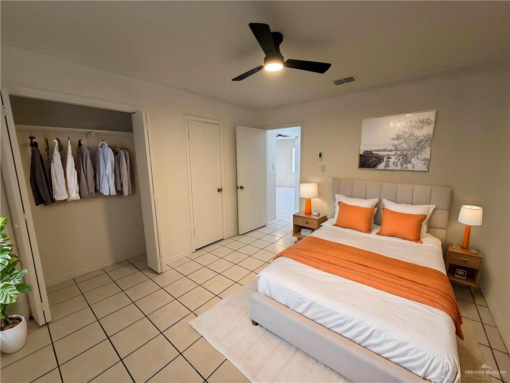 2612 West Mile 17 1/2 Road, Unit 12 Edinburg, TX 78541 - Photo 9 of 10 Bedroom featuring a ceiling fan with integrated lighting, tile flooring, and a built-in closet with hanging rod -Virtualy staged