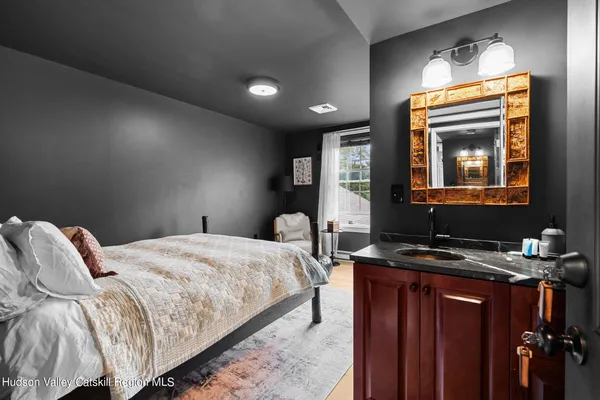a bedroom with a bed and dresser with mirror
