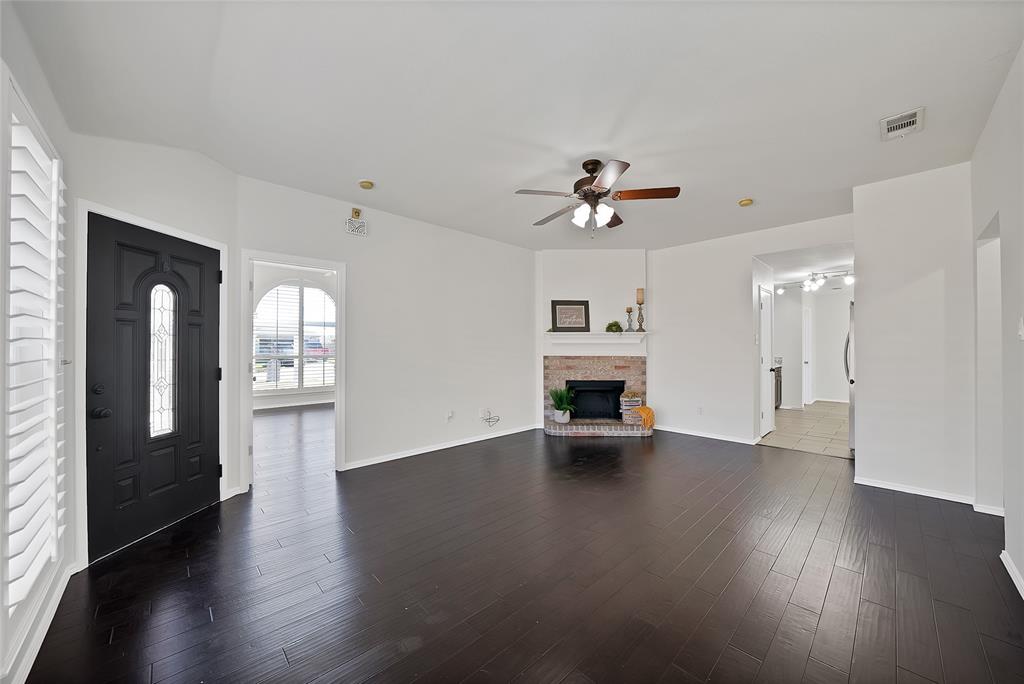 308 South Chestnut Street Forney, TX 75126 - Photo 12 of 25 a view of an empty room with a fireplace and wooden floor