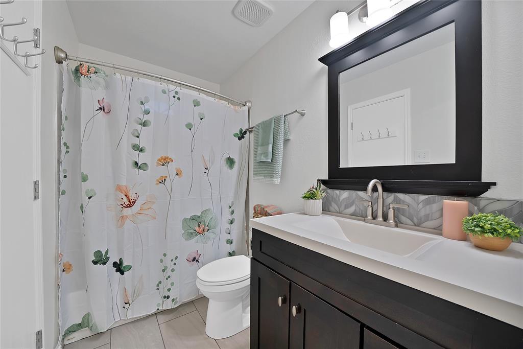 308 South Chestnut Street Forney, TX 75126 - Photo 19 of 25 a bathroom with a sink a toilet a mirror a vanity and shower