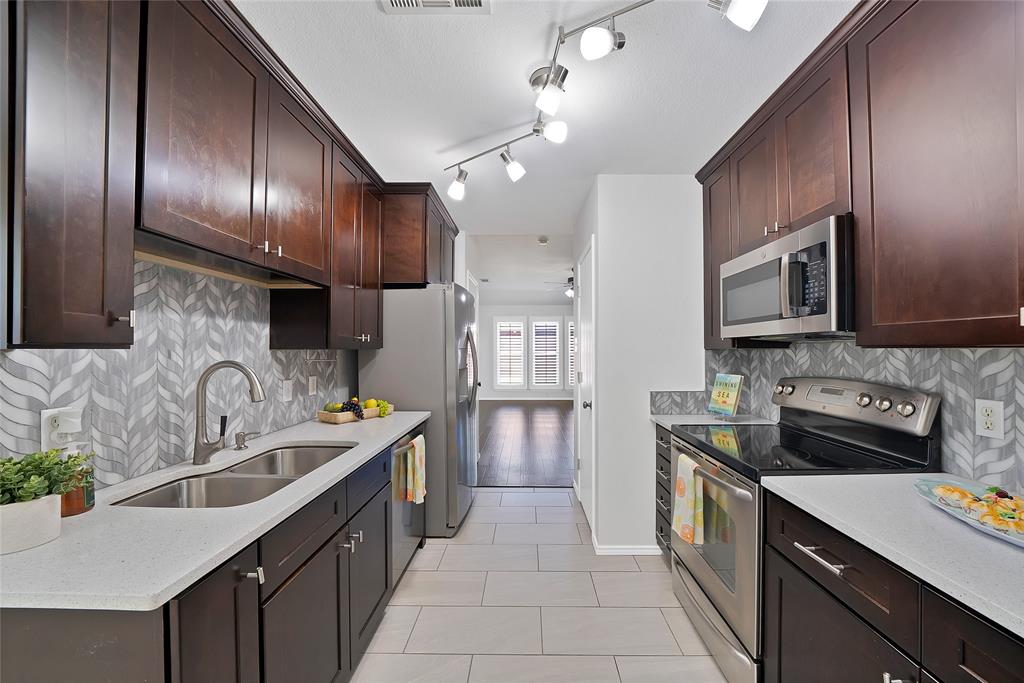 308 South Chestnut Street Forney, TX 75126 - Photo 3 of 25 a kitchen with stainless steel appliances granite countertop a sink stove and refrigerator