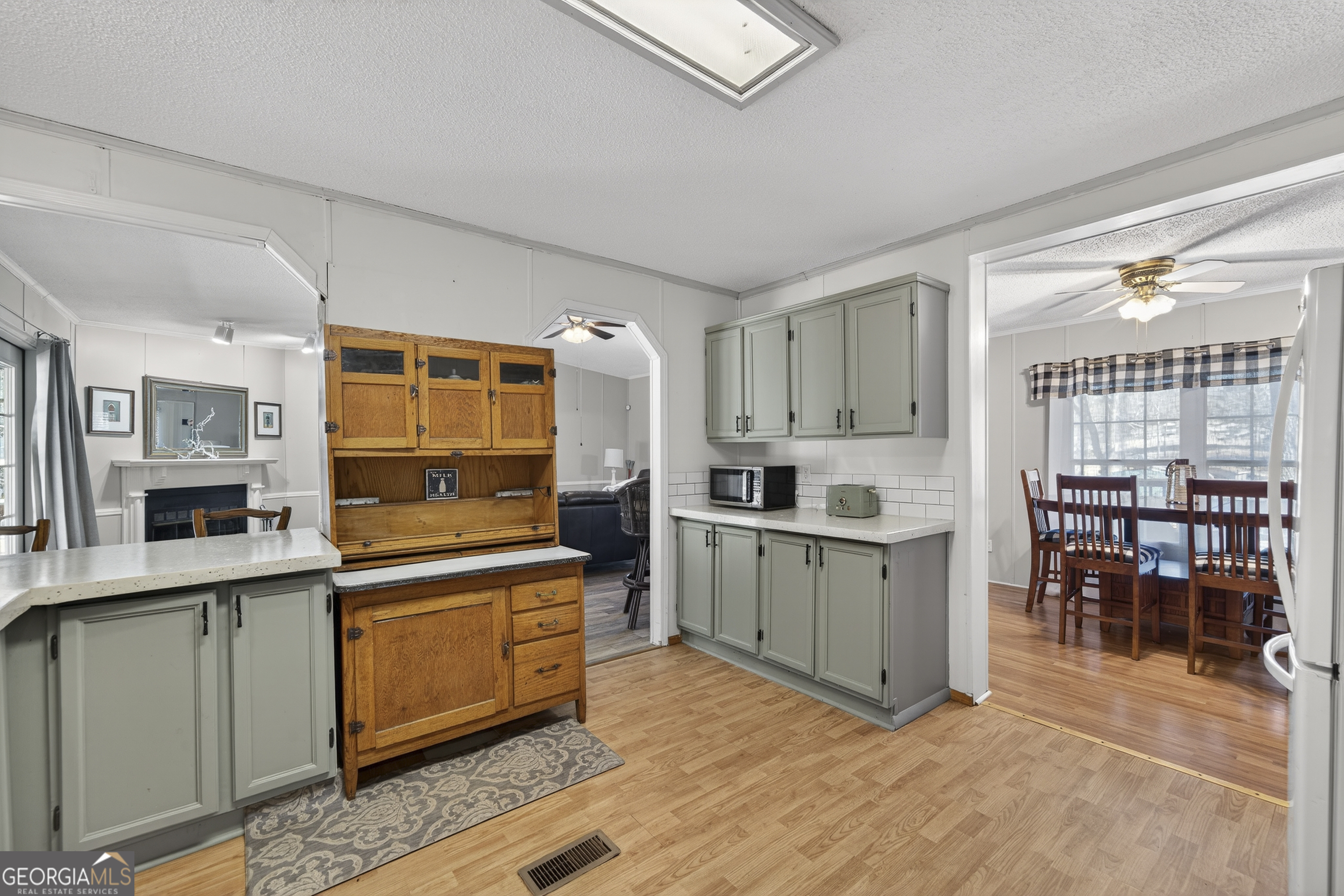 392 Hub Dent Road Northeast Milledgeville, GA 31061 - Photo 15 of 66 a kitchen with stainless steel appliances granite countertop a stove top oven a sink dishwasher a dining table and chairs with wooden floor