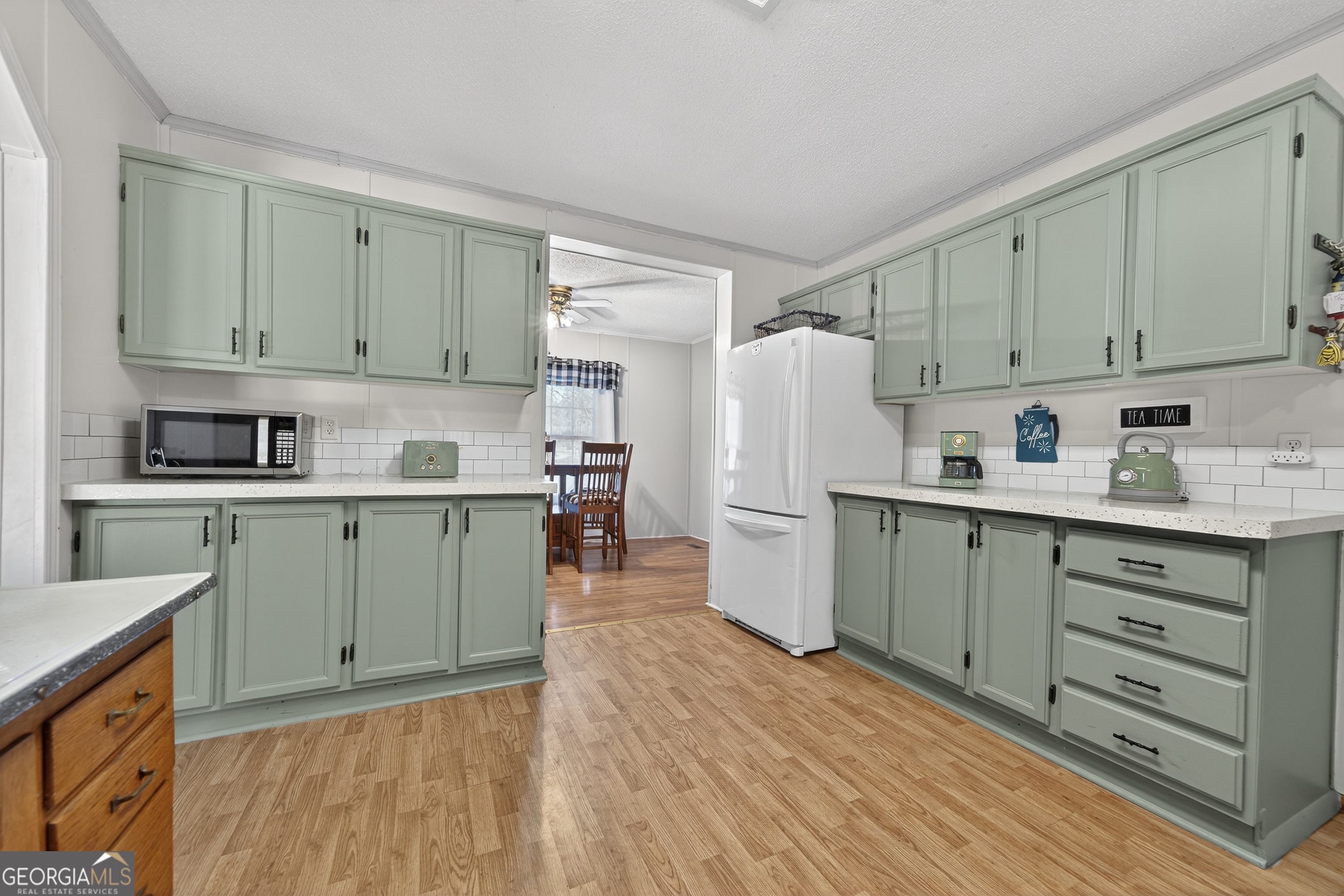 392 Hub Dent Road Northeast Milledgeville, GA 31061 - Photo 19 of 66 a kitchen with cabinets a refrigerator and a sink