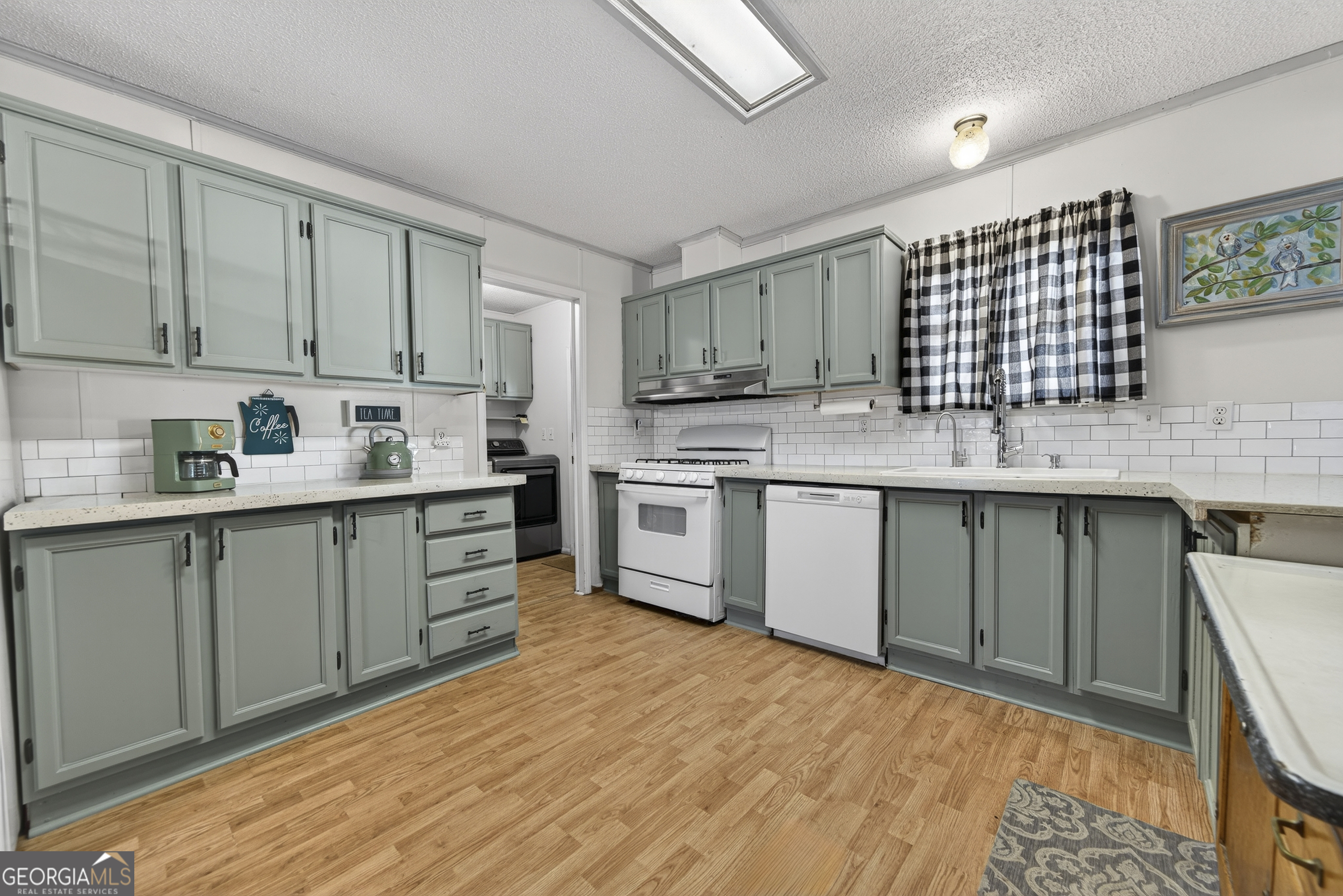392 Hub Dent Road Northeast Milledgeville, GA 31061 - Photo 20 of 66 a kitchen with stainless steel appliances granite countertop a sink a stove a refrigerator with grey cabinets