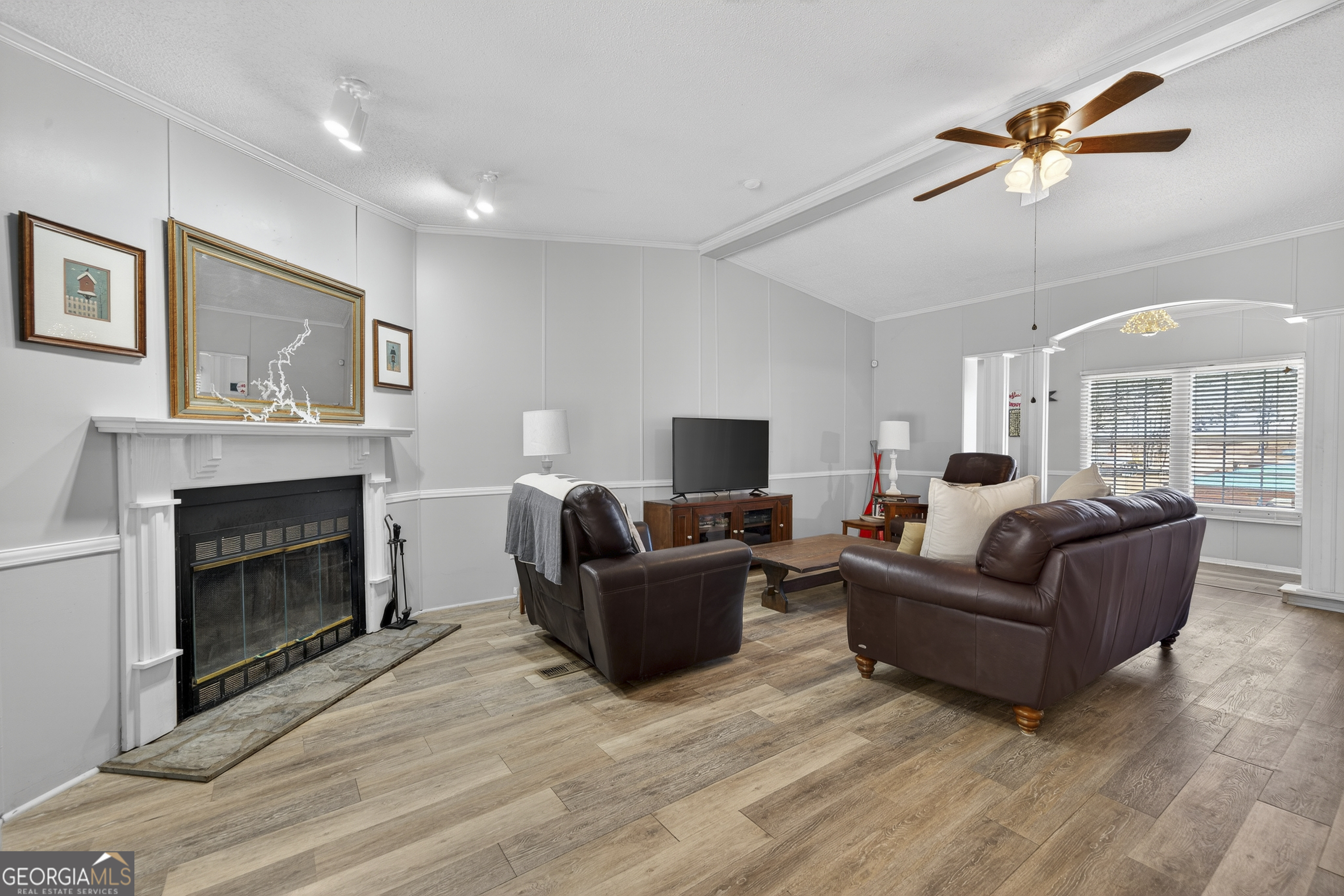 392 Hub Dent Road Northeast Milledgeville, GA 31061 - Photo 28 of 66 a living room with furniture a fireplace and a flat screen tv