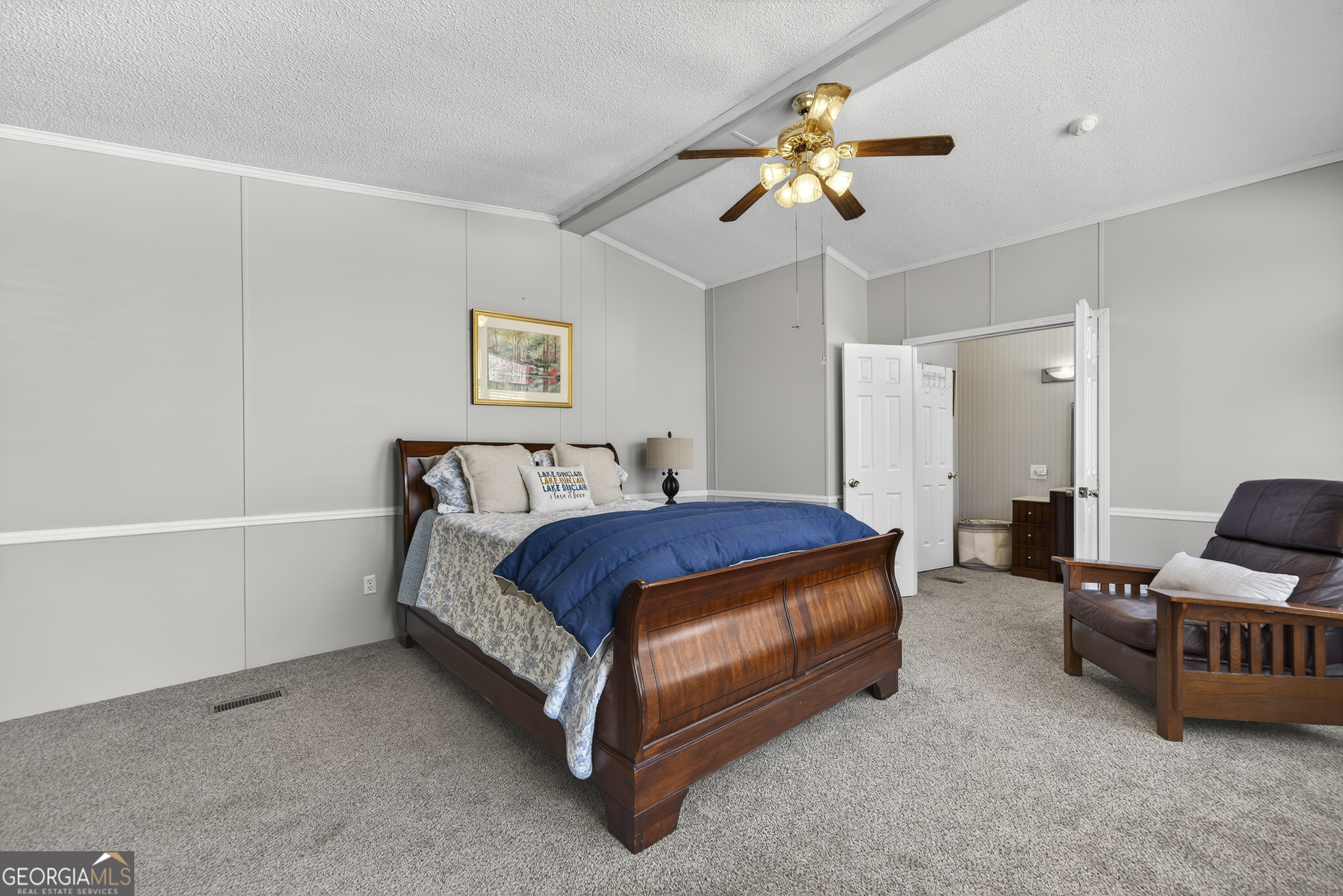 392 Hub Dent Road Northeast Milledgeville, GA 31061 - Photo 36 of 66 a spacious bedroom with a bed and a chandelier