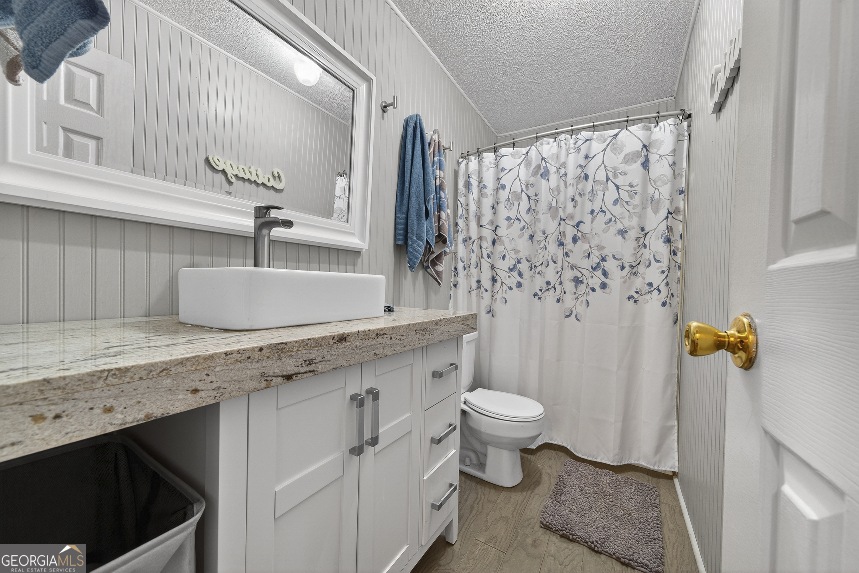 392 Hub Dent Road Northeast Milledgeville, GA 31061 - Photo 42 of 66 a bathroom with a granite countertop sink a toilet a mirror and shower curtain