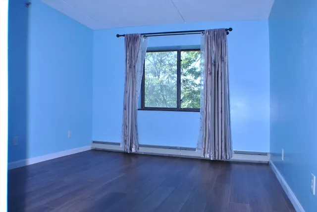 a view of a small space with wooden floor and a window