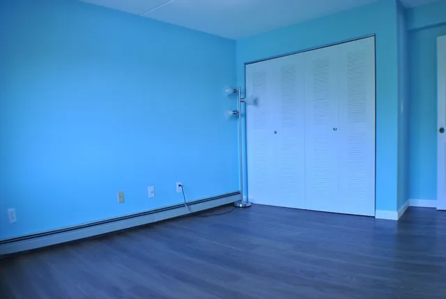 a view of an empty room with wooden floor