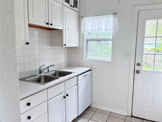 a kitchen with white cabinets and white appliances