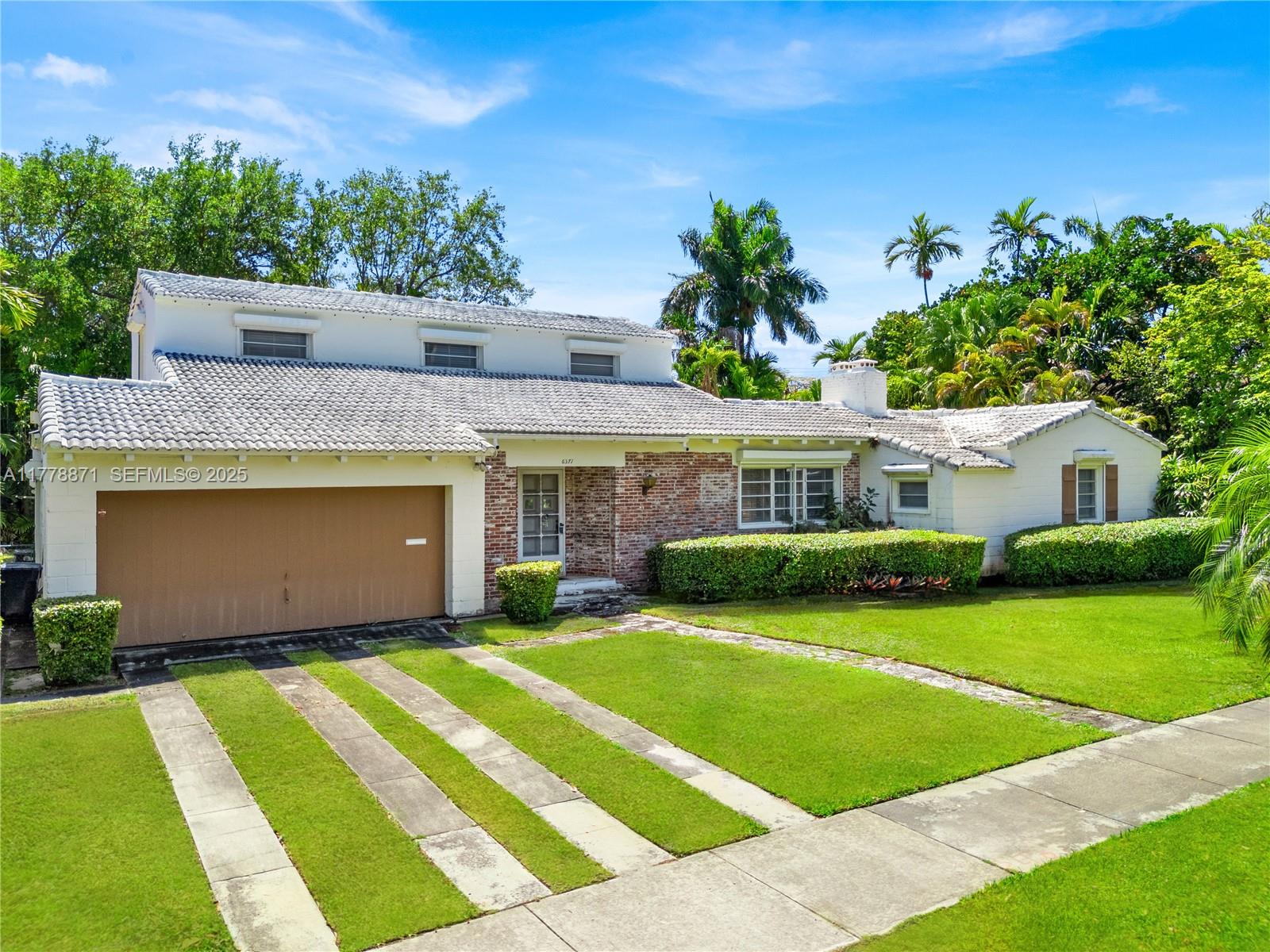 6371 North Bay Road Miami Beach, FL 33141 - Photo 21 of 26 a front view of a house with a yard and garage