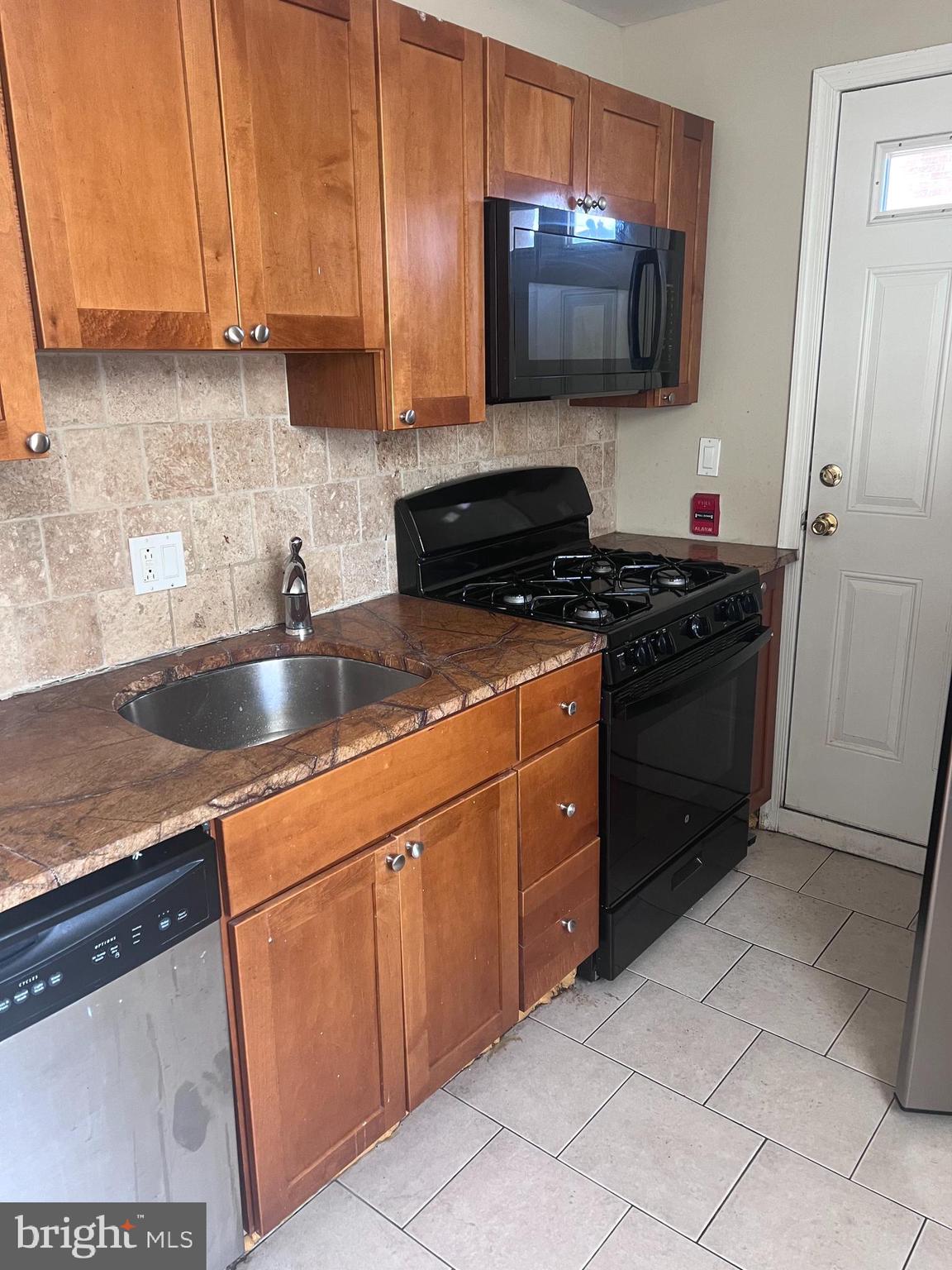 2151 South Hicks Street Philadelphia, PA 19145 - Photo 4 of 11 a kitchen with stainless steel appliances granite countertop a sink stove and microwave