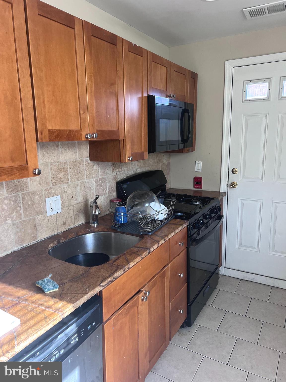 2151 South Hicks Street Philadelphia, PA 19145 - Photo 5 of 11 a kitchen with stainless steel appliances granite countertop a sink stove and microwave