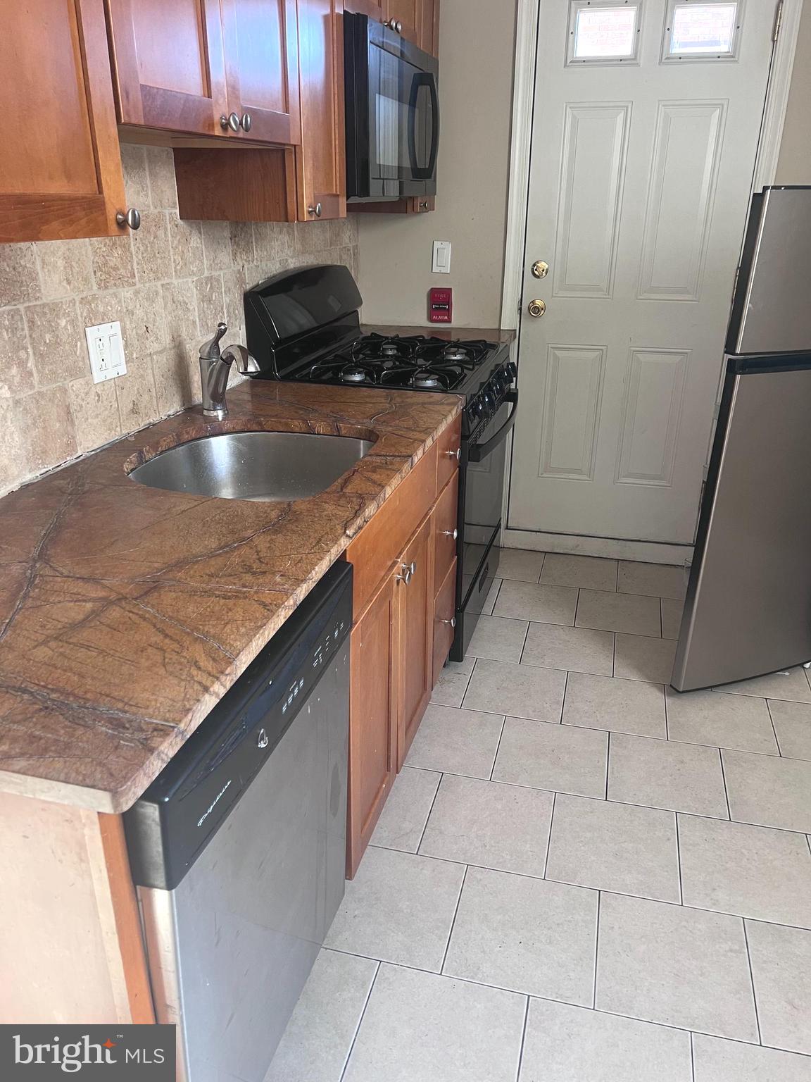 2151 South Hicks Street Philadelphia, PA 19145 - Photo 6 of 11 a kitchen with stainless steel appliances granite countertop a sink a stove and a microwave