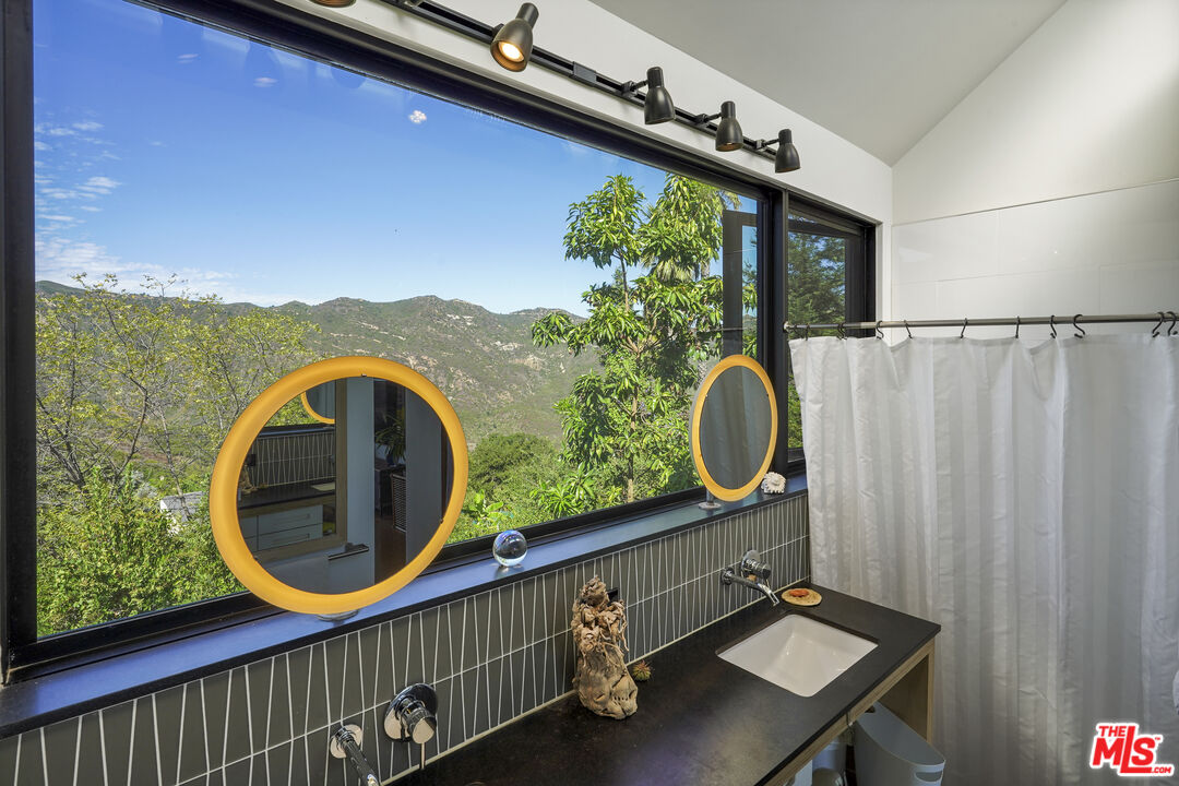 26335 Lockwood Road Malibu, CA 90265 - Photo 18 of 39 a bathroom with a sink a mirror and bathtub