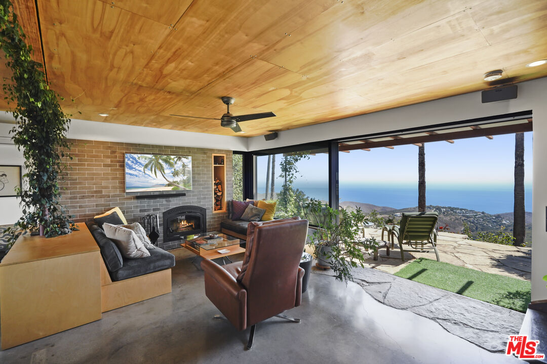 26335 Lockwood Road Malibu, CA 90265 - Photo 3 of 39 a living room with patio furniture and a floor to ceiling window