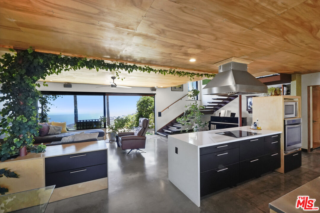26335 Lockwood Road Malibu, CA 90265 - Photo 9 of 39 a kitchen with stainless steel appliances kitchen island granite countertop a sink and counter space