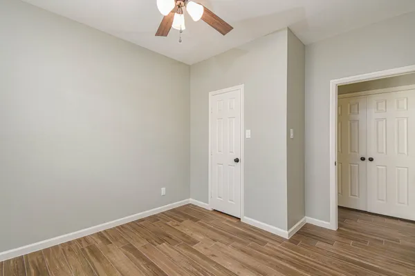 a view of an empty room with wooden floor
