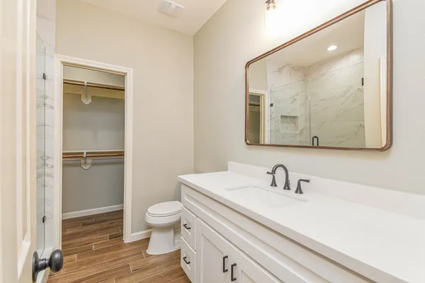 a bathroom with a sink a toilet and shower