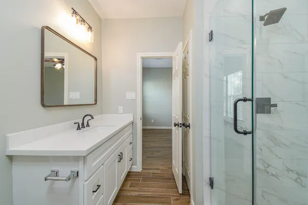 a bathroom with a double vanity sink mirror and shower