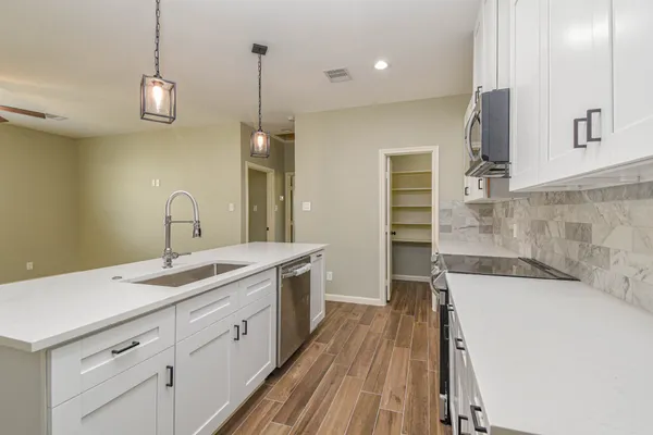 a spacious bathroom with a sink a large mirror and a bathtub