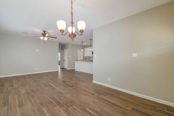 a view of a room with wooden floor and a ceiling fan