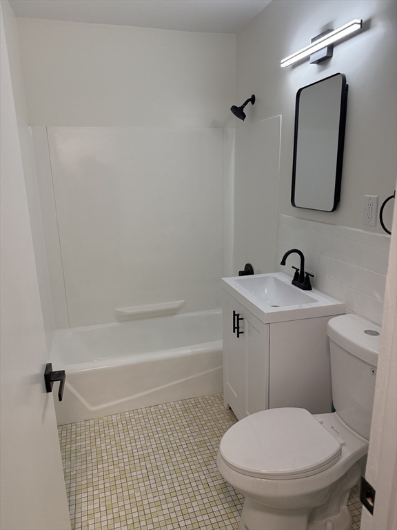 115 Grove Street, Unit 1 Boston, MA 02132 - Photo 7 of 15 a bathroom with a toilet a sink and bathtub