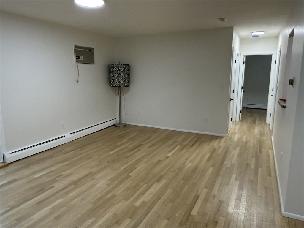 115 Grove Street, Unit 1 Boston, MA 02132 - Photo 9 of 15 a view of a hallway with wooden floor