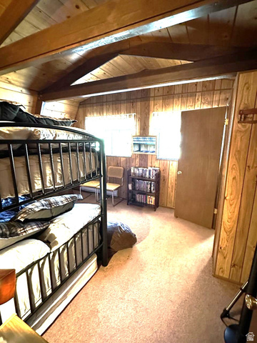 1456 Navajo Road Coalville, UT 84017 - Photo 30 of 55 Bedroom featuring wood walls, light colored carpet, and a wooden ceiling with exposed beams