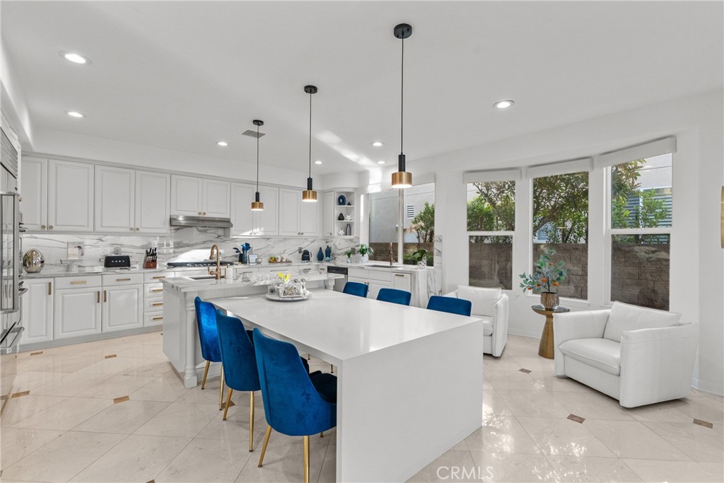 20366 Vía Galileo Porter Ranch, CA 91326 - Photo 32 of 75 a kitchen with a sink stove and white cabinets with wooden floor