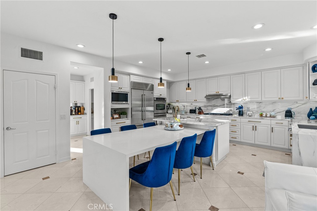 20366 Vía Galileo Porter Ranch, CA 91326 - Photo 34 of 75 a kitchen with stainless steel appliances kitchen island granite countertop a sink and cabinets