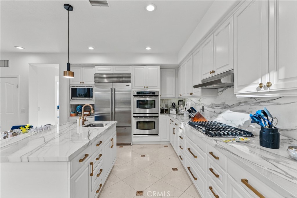 20366 Vía Galileo Porter Ranch, CA 91326 - Photo 38 of 75 a kitchen with stainless steel appliances kitchen island granite countertop a stove and a sink