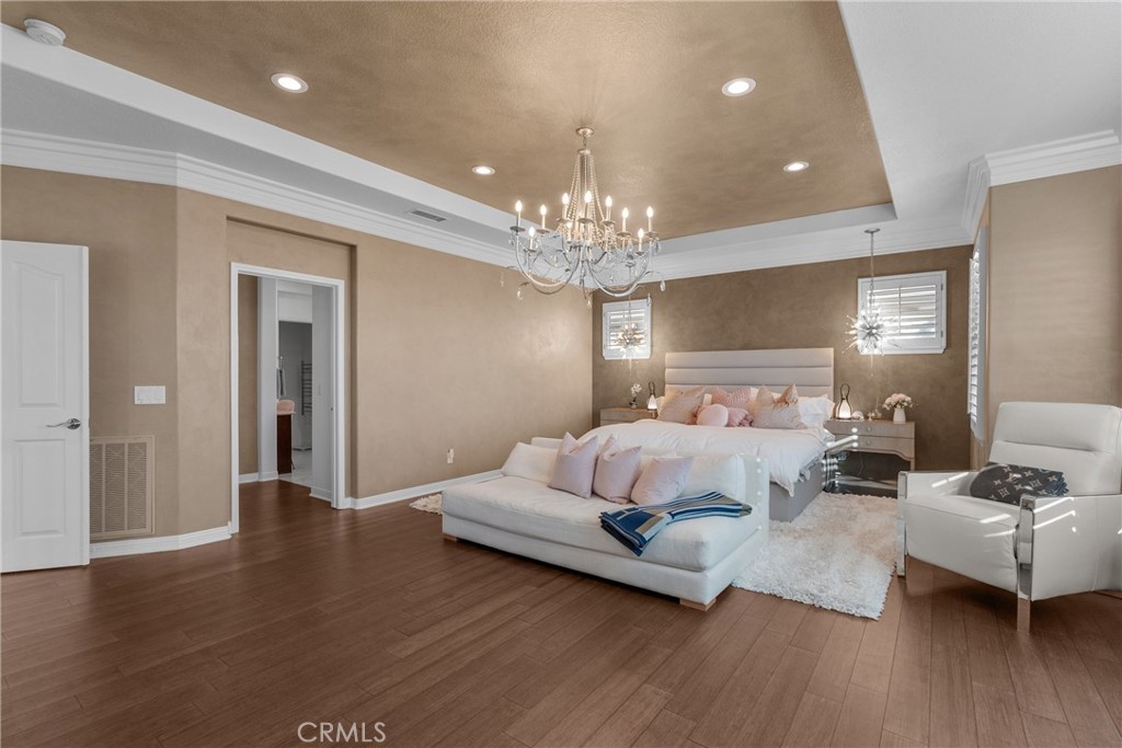 20366 Vía Galileo Porter Ranch, CA 91326 - Photo 67 of 75 a spacious bedroom with a bed and wooden floor