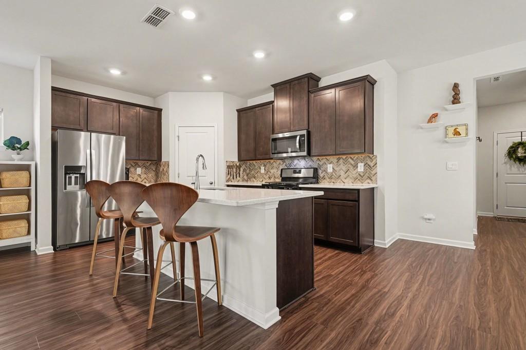 4740 Electric Avenue Southwest Mableton, GA 30126 - Photo 3 of 51 a kitchen with stainless steel appliances granite countertop wooden floors a stove and a refrigerator