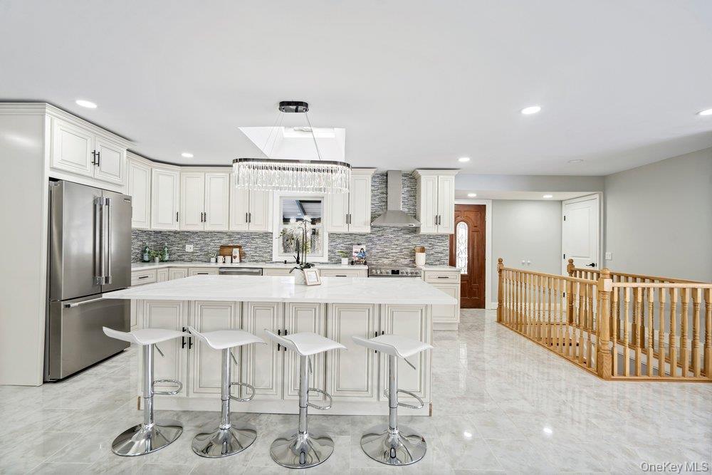 497 Woodbury Road Cold Spring Harbor, NY 11724 - Photo 11 of 24 a kitchen with stainless steel appliances granite countertop a refrigerator and white cabinets