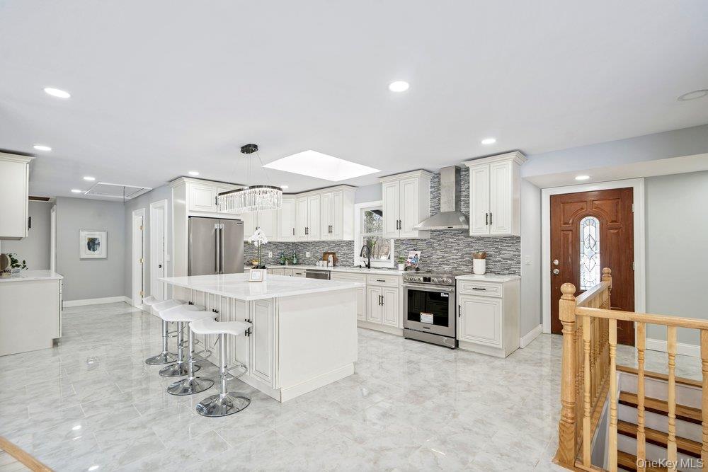 497 Woodbury Road Cold Spring Harbor, NY 11724 - Photo 12 of 24 a large kitchen with kitchen island a sink stainless steel appliances and cabinets