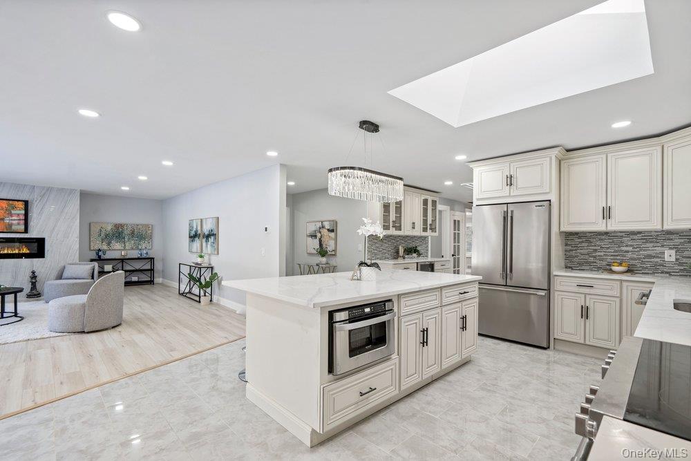 497 Woodbury Road Cold Spring Harbor, NY 11724 - Photo 15 of 24 a large kitchen with stainless steel appliances a stove a sink a oven a dining table and chairs