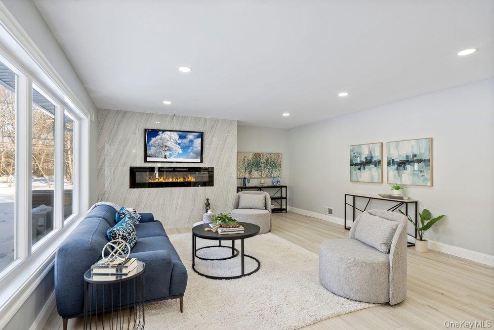 497 Woodbury Road Cold Spring Harbor, NY 11724 - Photo 5 of 24 a living room with furniture and a flat screen tv