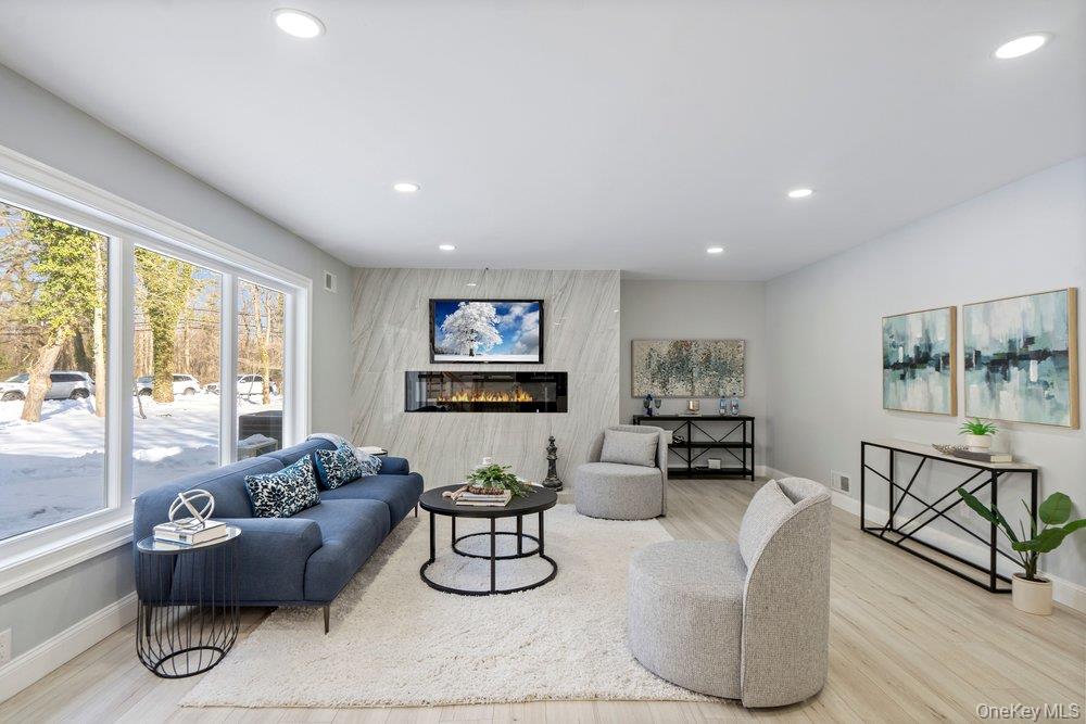 497 Woodbury Road Cold Spring Harbor, NY 11724 - Photo 6 of 24 a living room with furniture and a floor to ceiling window