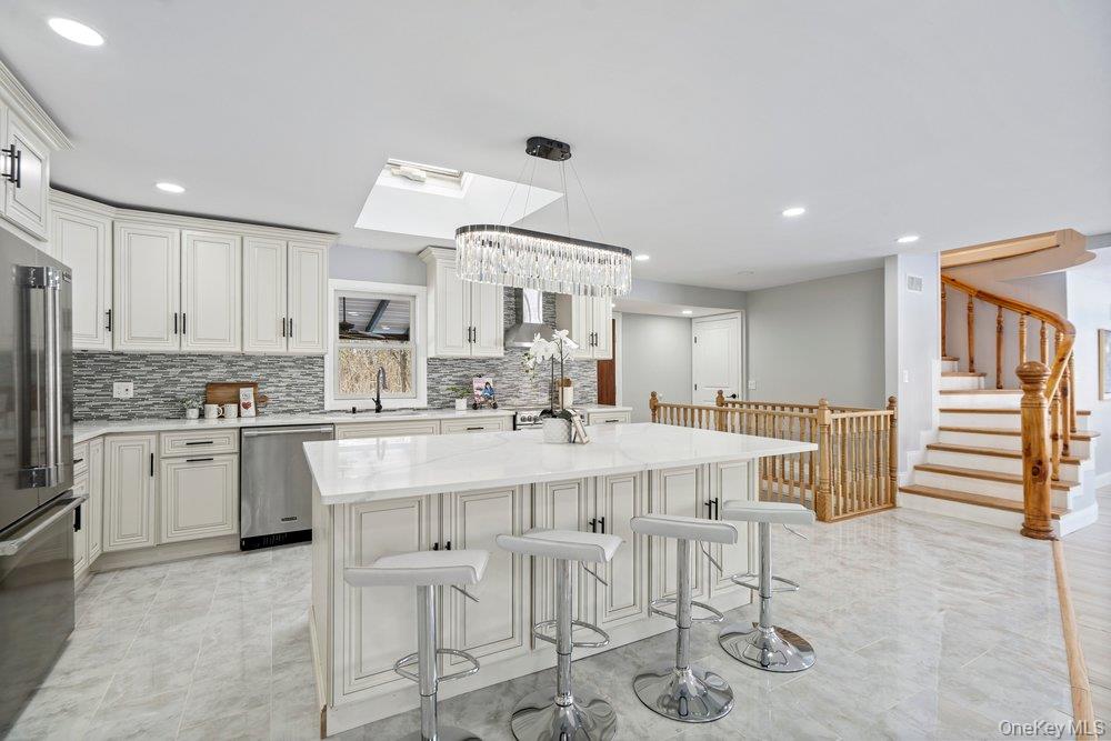 497 Woodbury Road Cold Spring Harbor, NY 11724 - Photo 10 of 24 a kitchen with stainless steel appliances kitchen island granite countertop a sink and cabinets