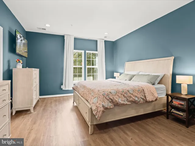 a large bed sitting in a bedroom next to a window with lamp