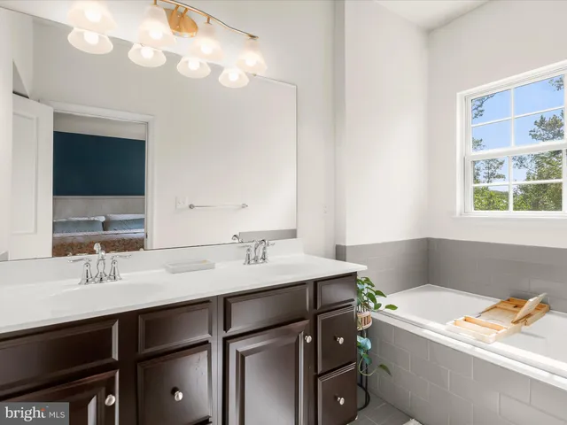 a bathroom with a tub sink and mirror
