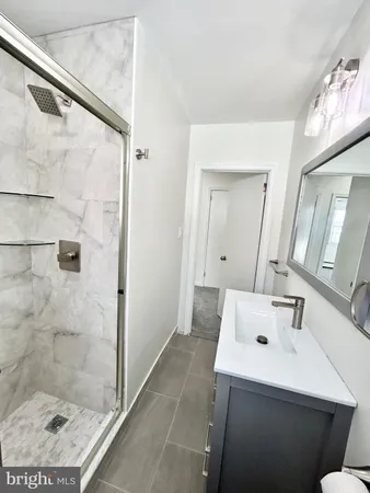 a bathroom with a sink mirror and shower
