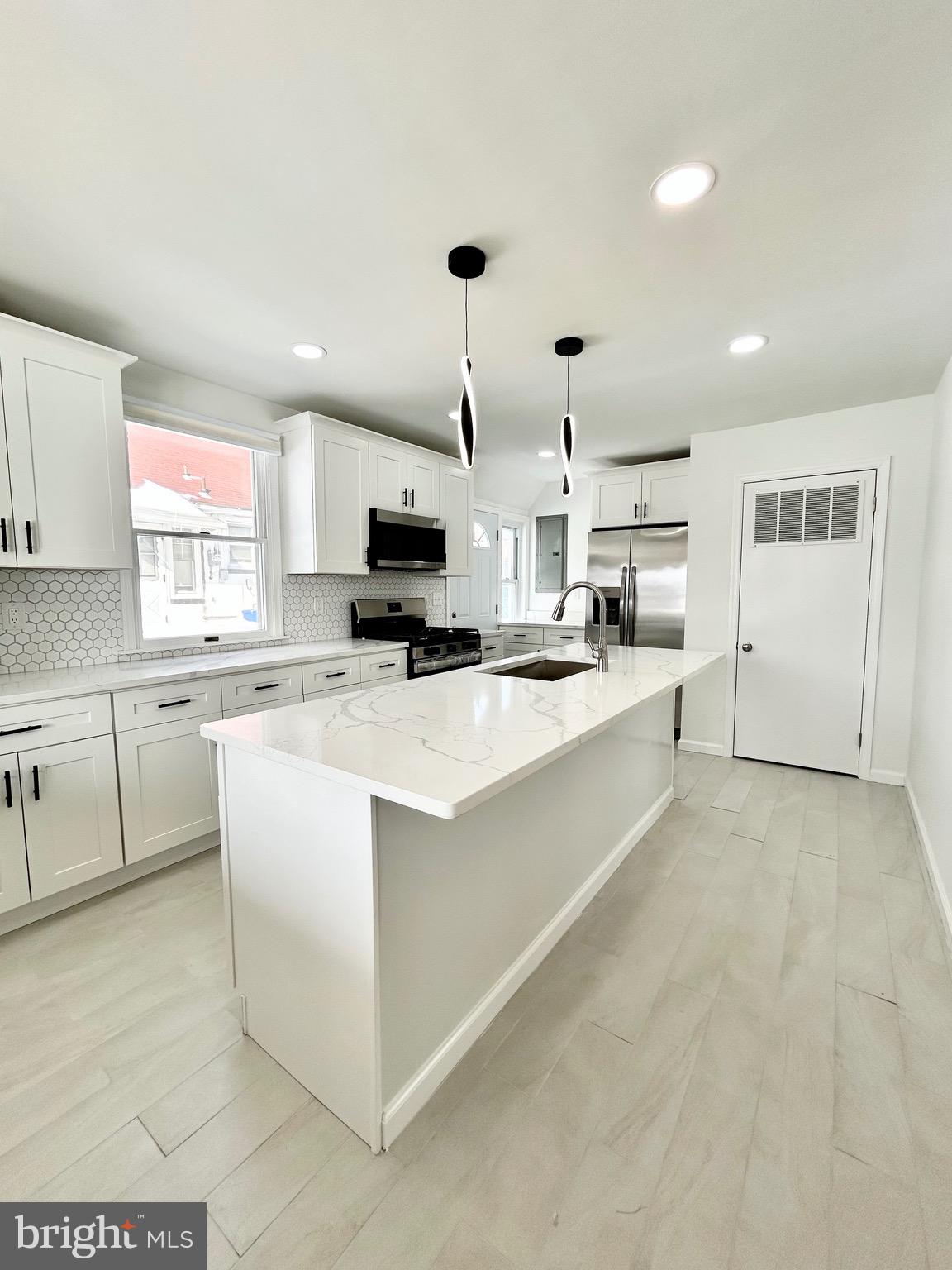 1007 Ripley Street Philadelphia, PA 19111 - Photo 6 of 39 a large white kitchen with a window and stainless steel appliances