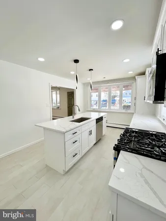 a kitchen with stainless steel appliances a sink stove and cabinets