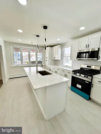 a kitchen with stainless steel appliances kitchen island a stove a sink a refrigerator and cabinets