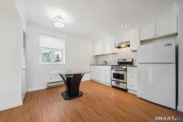 a kitchen with a refrigerator and white cabinets