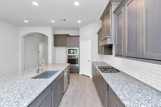 a view of empty room with kitchen and sink